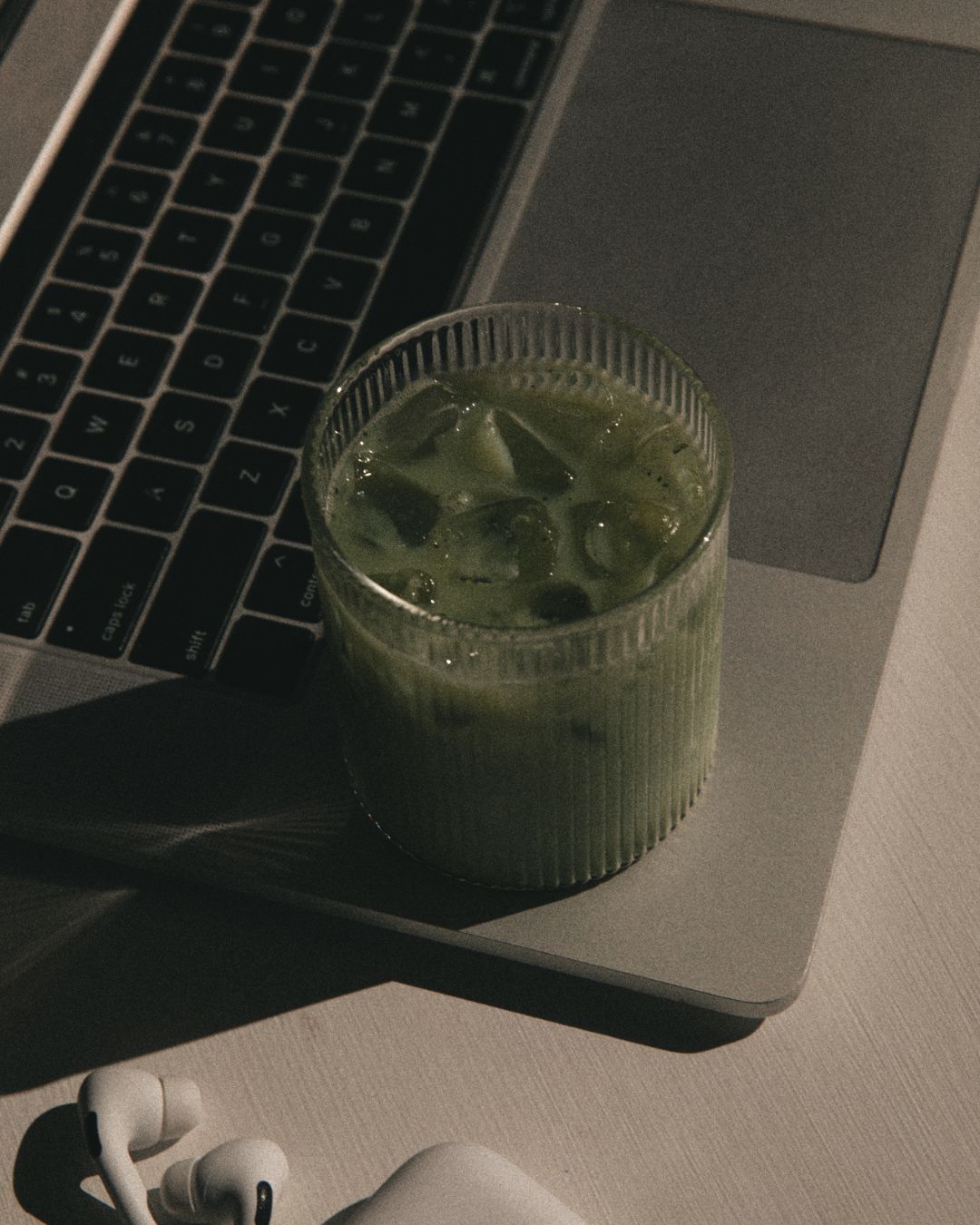 A cup of iced maccha on laptop