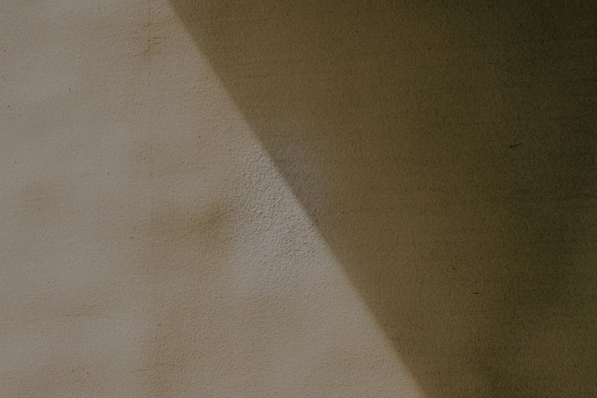 Neutral concrete wall with a sharp shadow across.