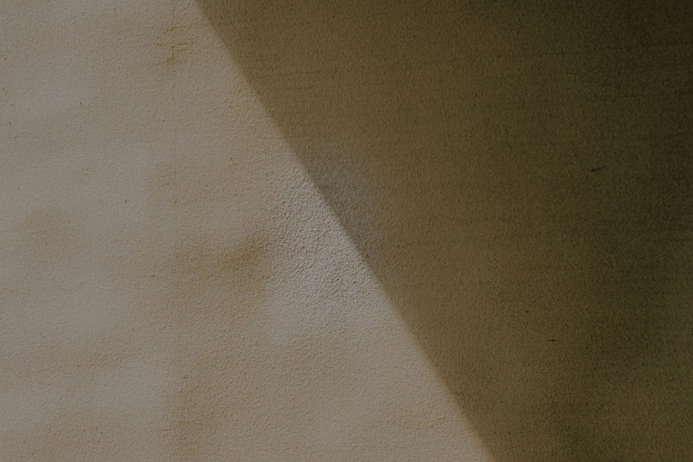 Neutral concrete wall with a sharp shadow across.