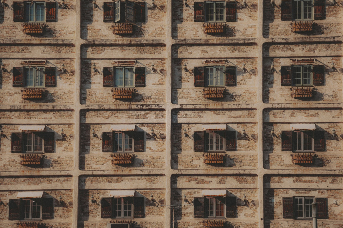 Uniform windows on a neutral stone wall.