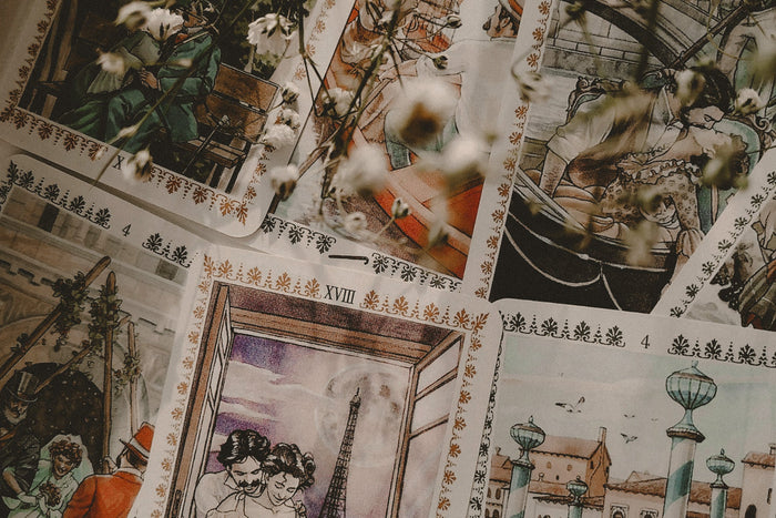 Tarot cards spread on a neutral surface with flowers.