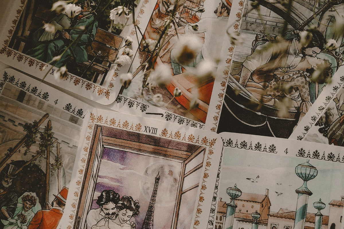 Tarot cards spread on a neutral surface with flowers.
