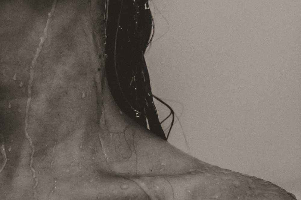 Editorial monochrome image of woman with wet hair and wet skin.