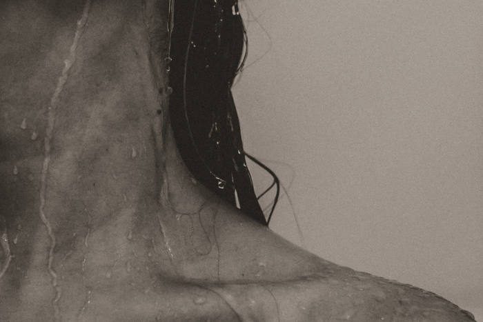 Editorial monochrome image of woman with wet hair and wet skin.