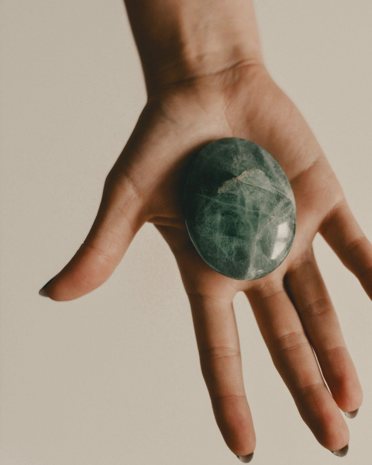 Tumbled green aventurine on an open palm