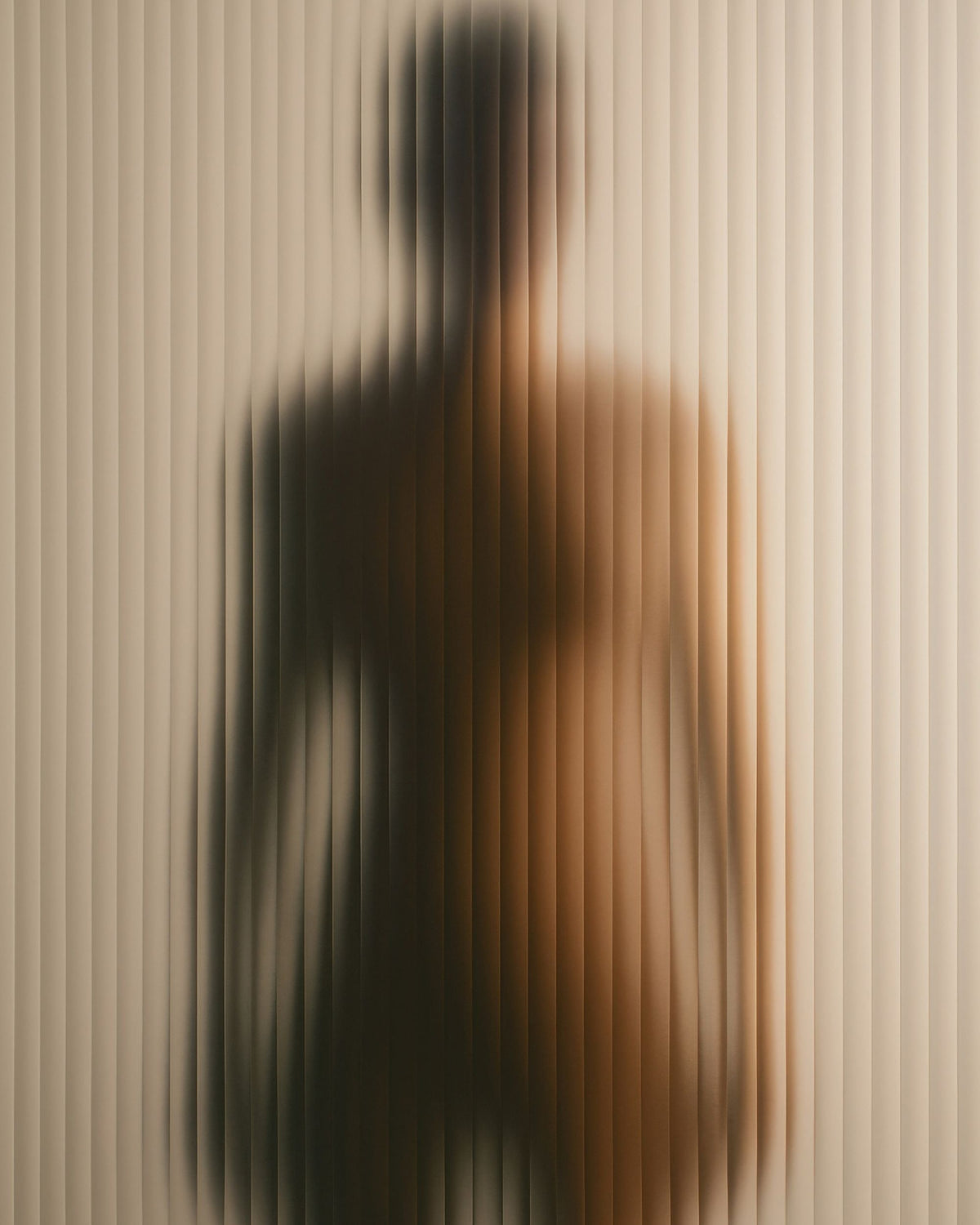 Monochrome image of woman's bare back with her head down.