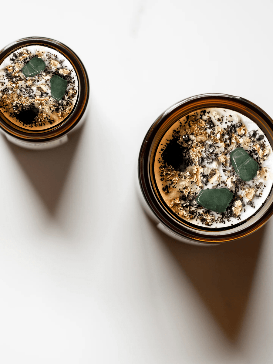 Top view of Abundance ritual candles with green aventurine, botanicals, and gold leaf.