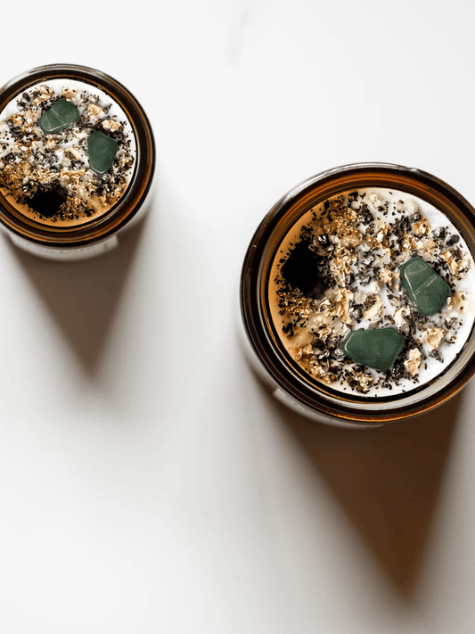 Top view of Abundance ritual candles with green aventurine, botanicals, and gold leaf.