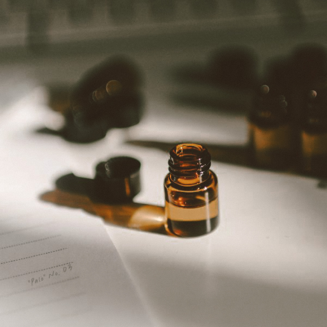 Amber glass bottle with a dropper on a piece of paper with text.