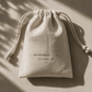 Linen drawstring pouch with 'Alchemist + Co.' branding on a beige background