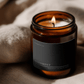 Lit Alignment ritual candle beside textured linen in warm atmospheric light.