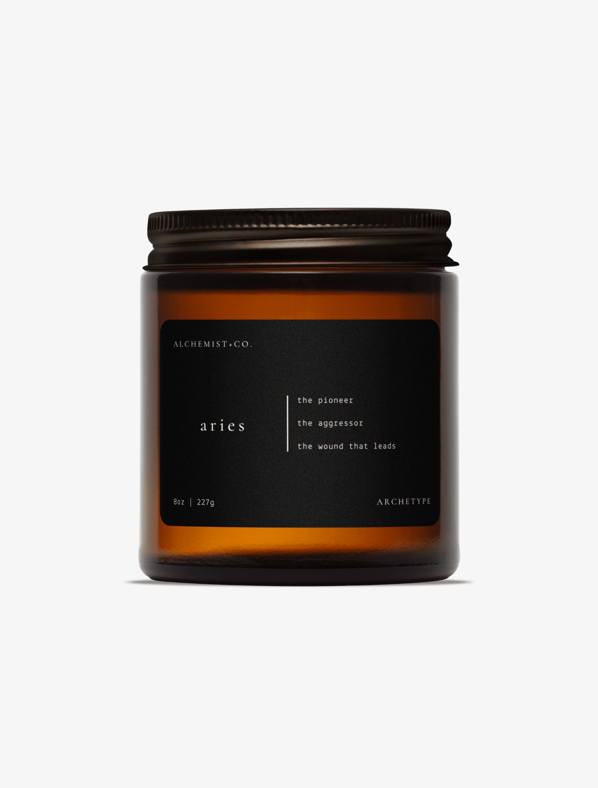 Aries scented candle by Alchemist + Co. in an amber glass jar with a black label