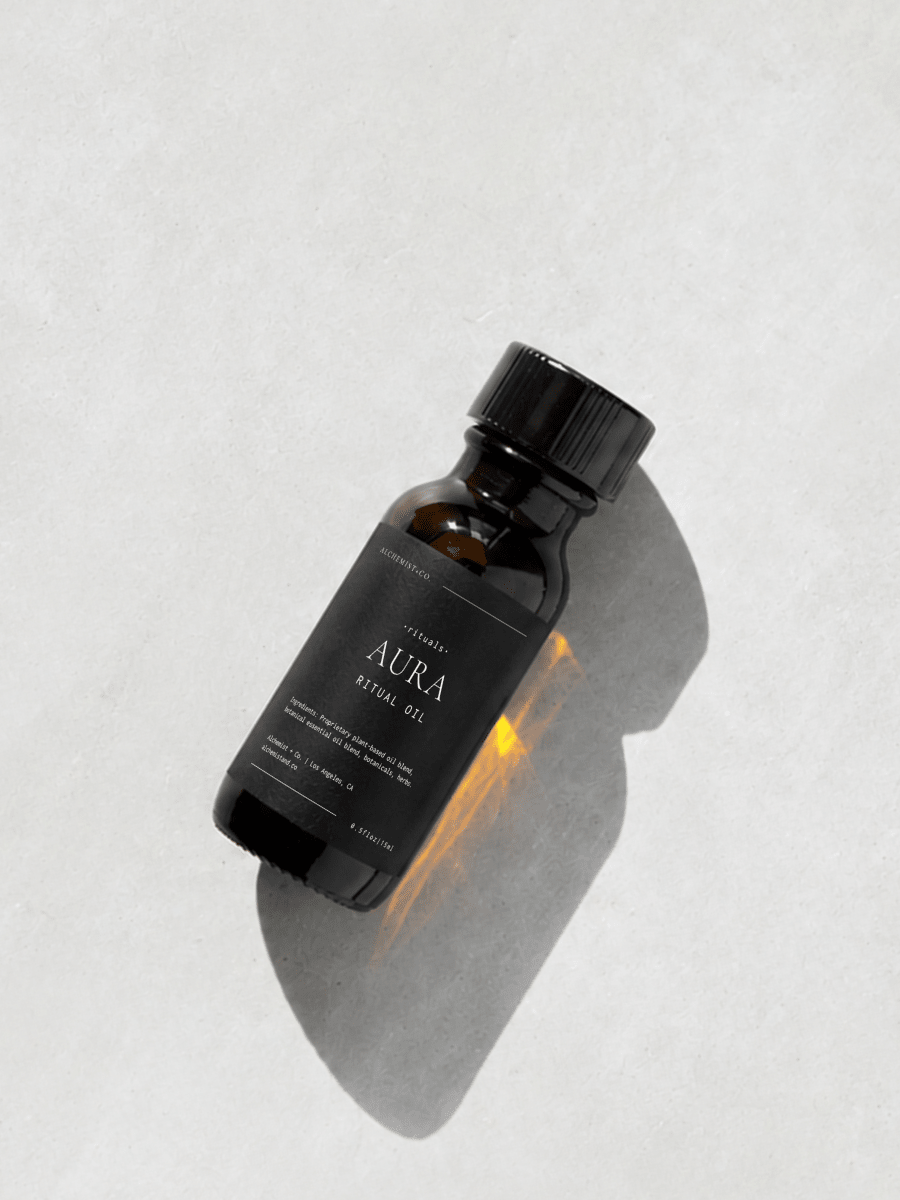 Bottle of "Aura" ritual oil on light gray background.
