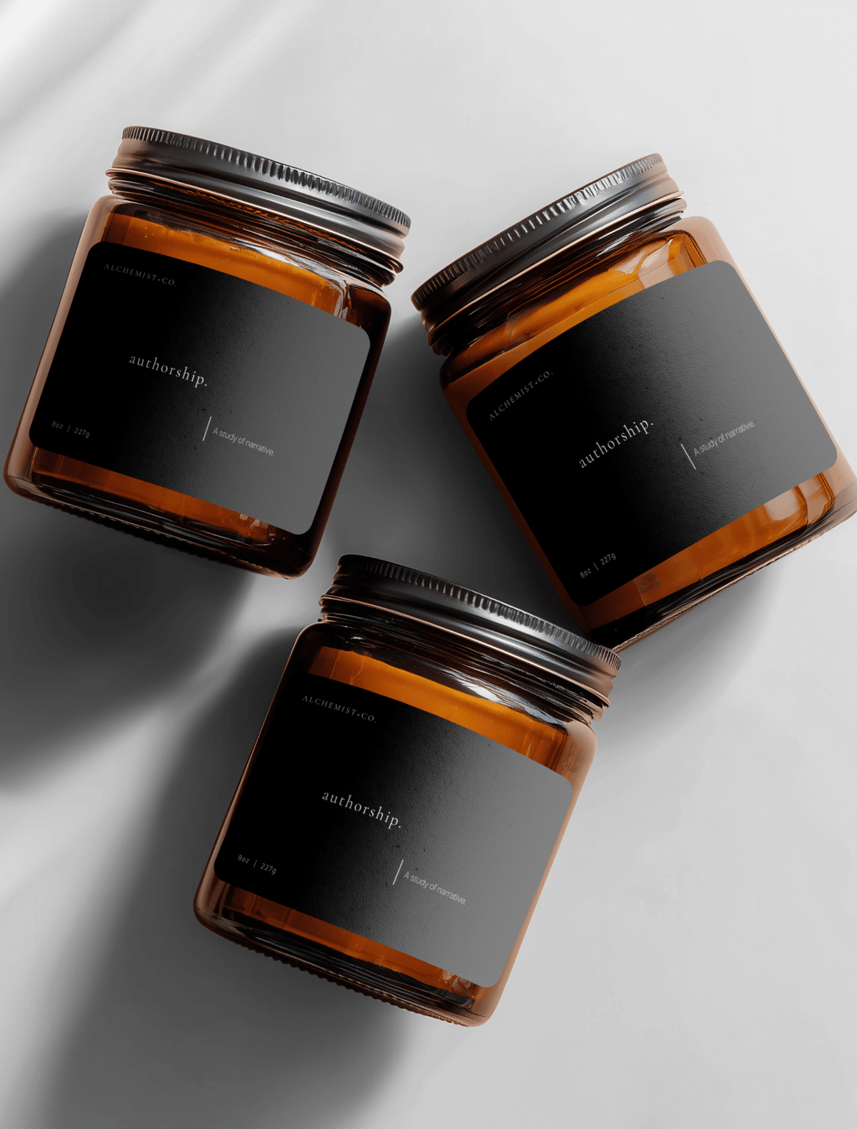 Three Authorship candles in amber glass jars