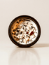 Awakening ritual candle with carnelian, citrine, quartz, and botanical details viewed from above.