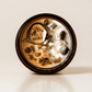 Ayahuasca ritual candle with botswana agate, peridot, quartz, and botanical details viewed from above.
