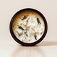 Breathwork ritual candle with quartz and botanical details viewed from above.
