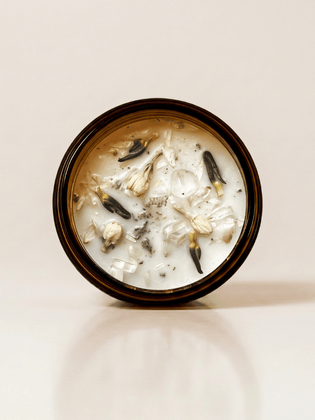 Breathwork ritual candle with quartz and botanical details viewed from above.