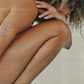 Cancer woman crouched down in defeated position on a neutral background.