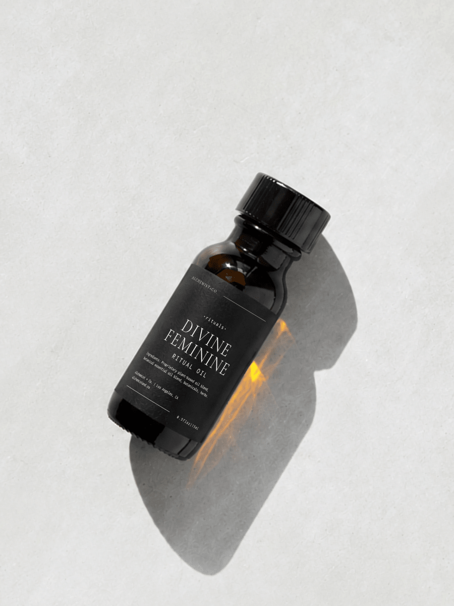 Bottle of "Divine Feminine" ritual oil on a light gray background.
