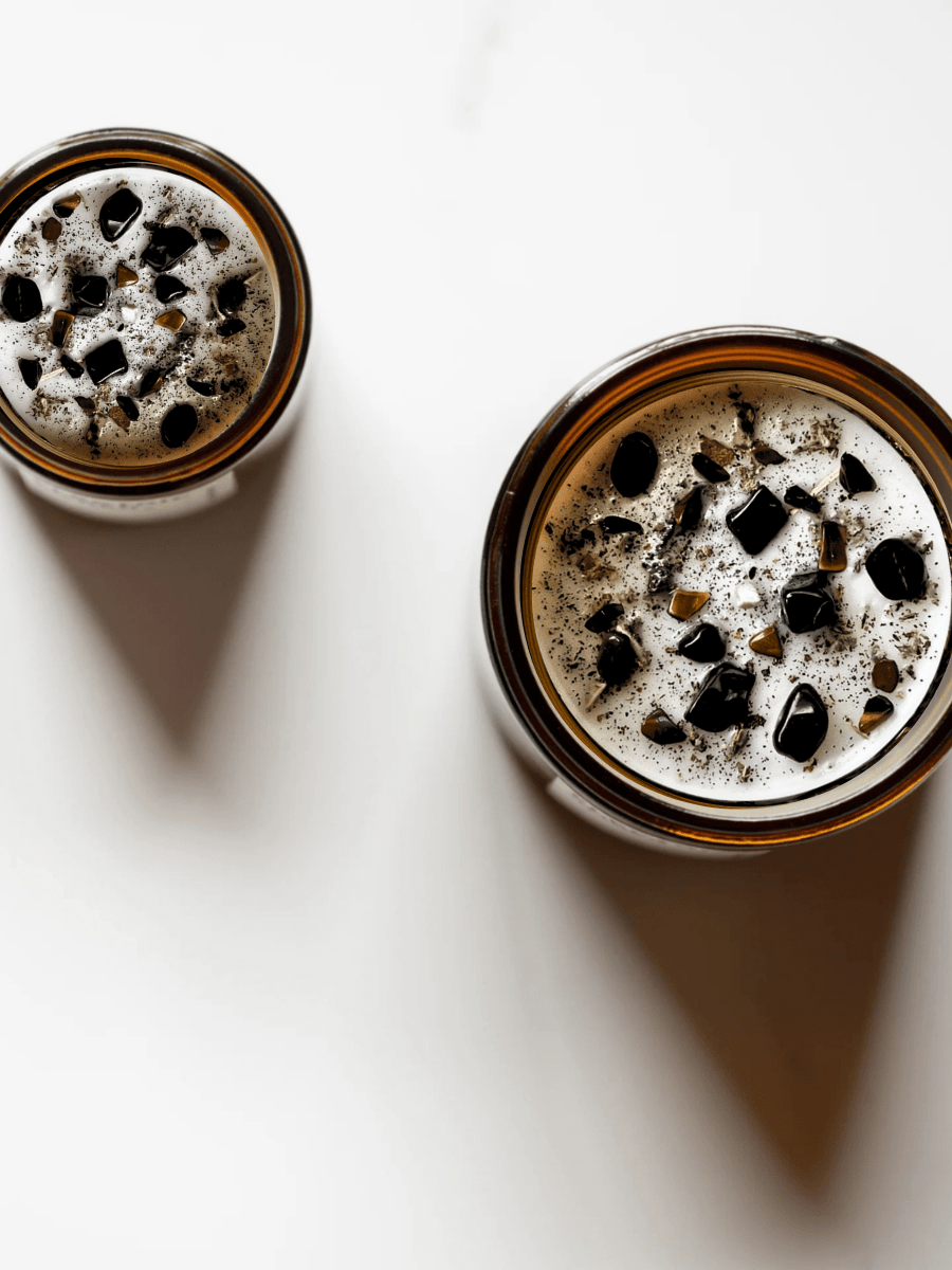 Top view of Divine Masculine ritual candles with black tourmaline, smoky quartz, tigers eye, and botanicals.