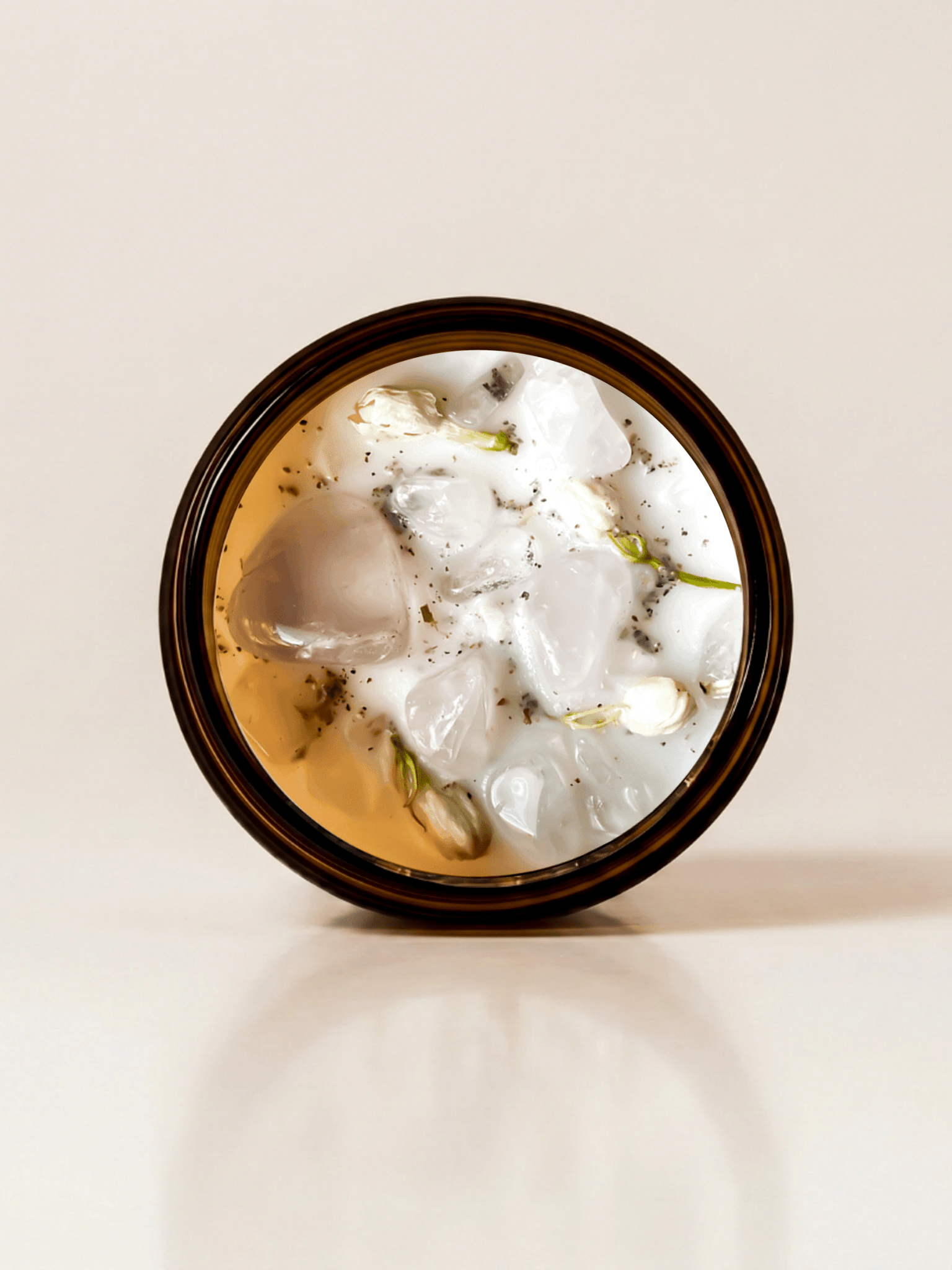 Drift ritual candle with quartz, rose quartz, and botanical detail viewed from above.