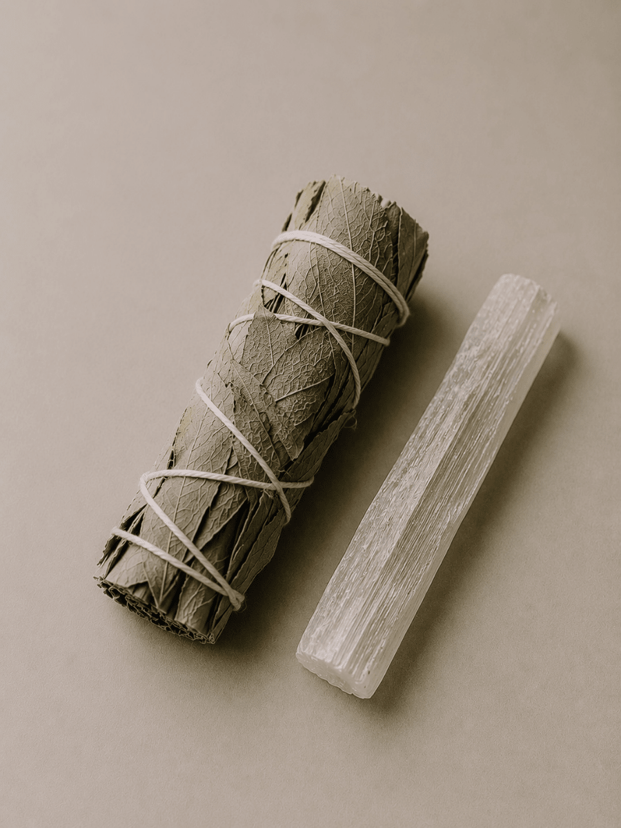 Rolled sage bundle and selenite wand on a beige background.