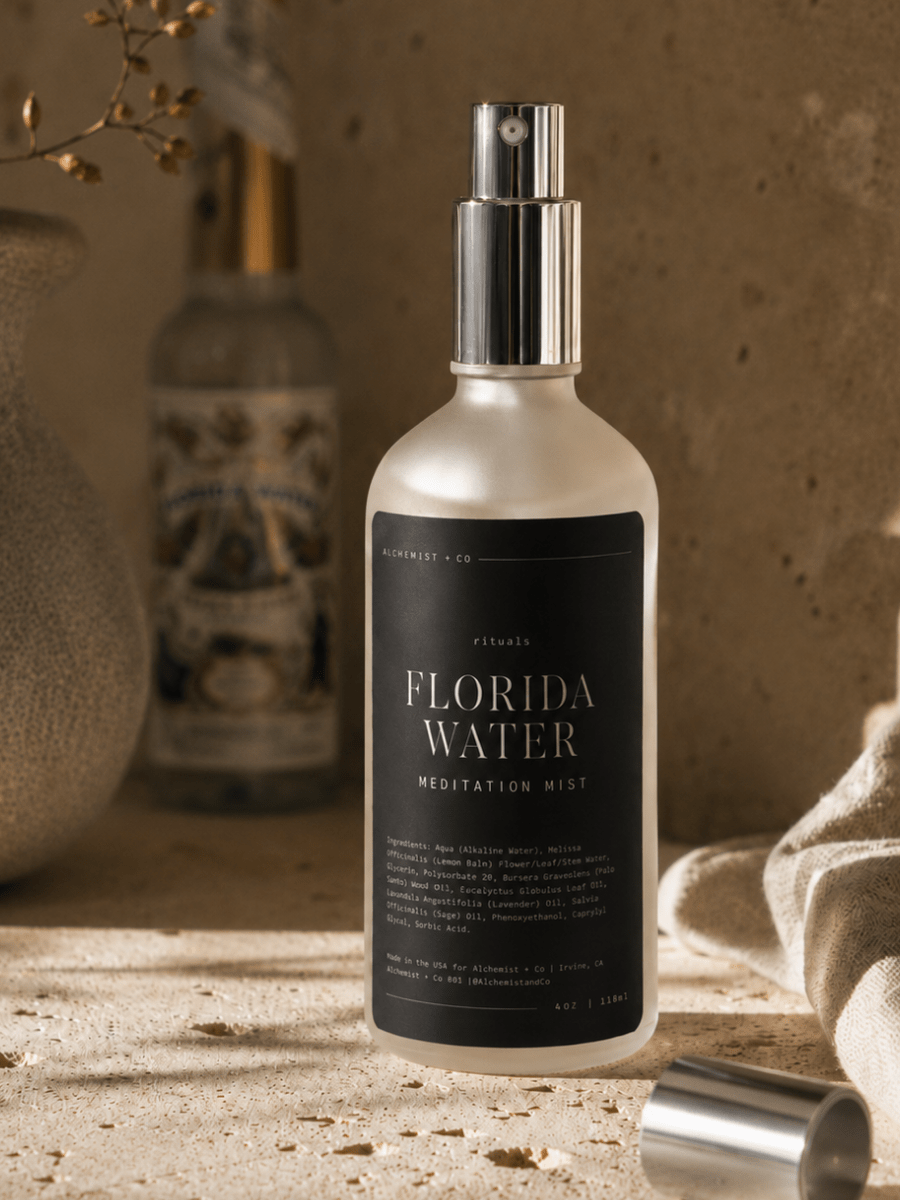 Bottle of 'Florida Water Meditation Mist' on a textured surface with decorative items in the background.