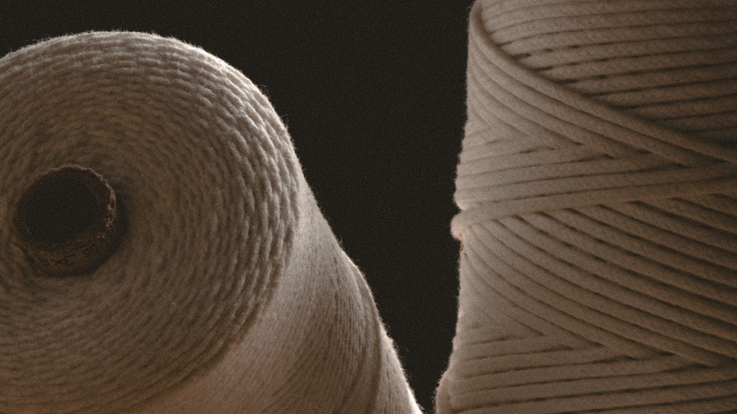 Two spools of cotton wicks against a black background.