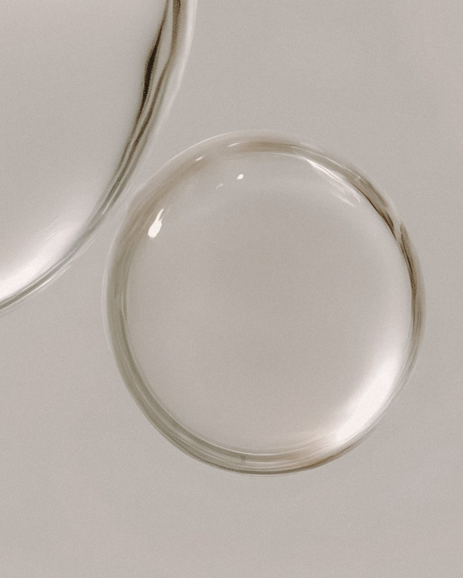 Close-up of a fragrance drop on a light gray background.