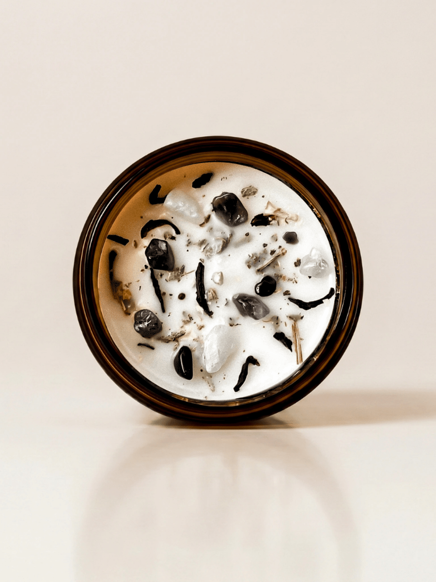 Full Moon ritual candle with amethyst, black tourmaline, moonstone, botanical details viewed from above. 