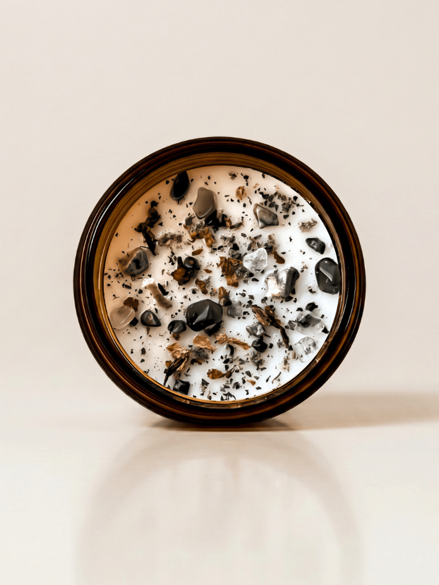 Gaia ritual candle with rainforest rhyolite, smoky quartz, quartz, and botanical details viewed from above.