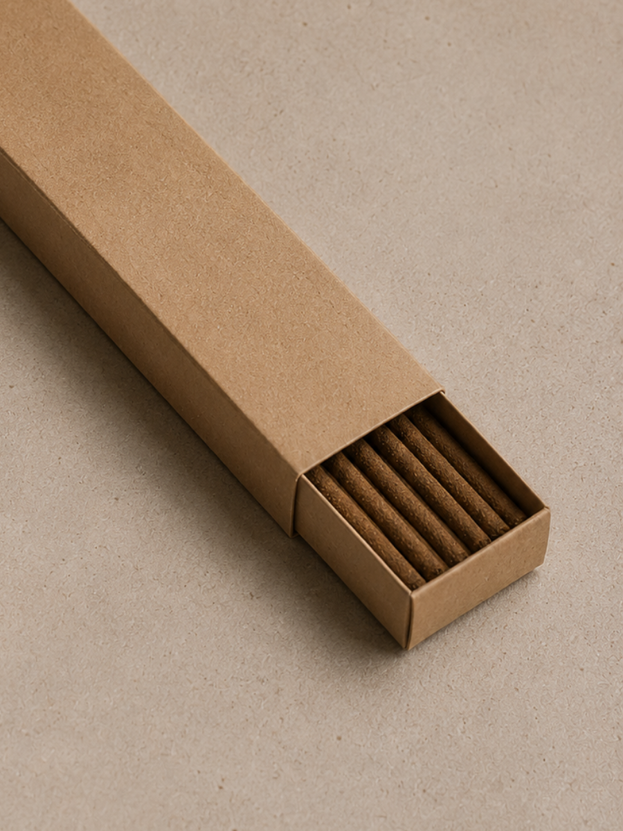 Brown Alchemist + Co. kraft packaging box with incense sticks on a beige background