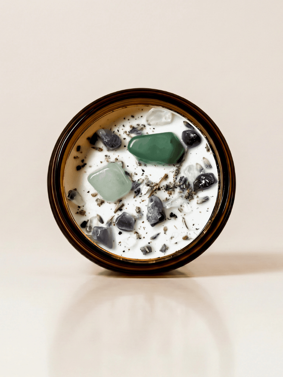 Heal ritual candle with green aventurine, amethyst, quartz, botanical details viewed from above.