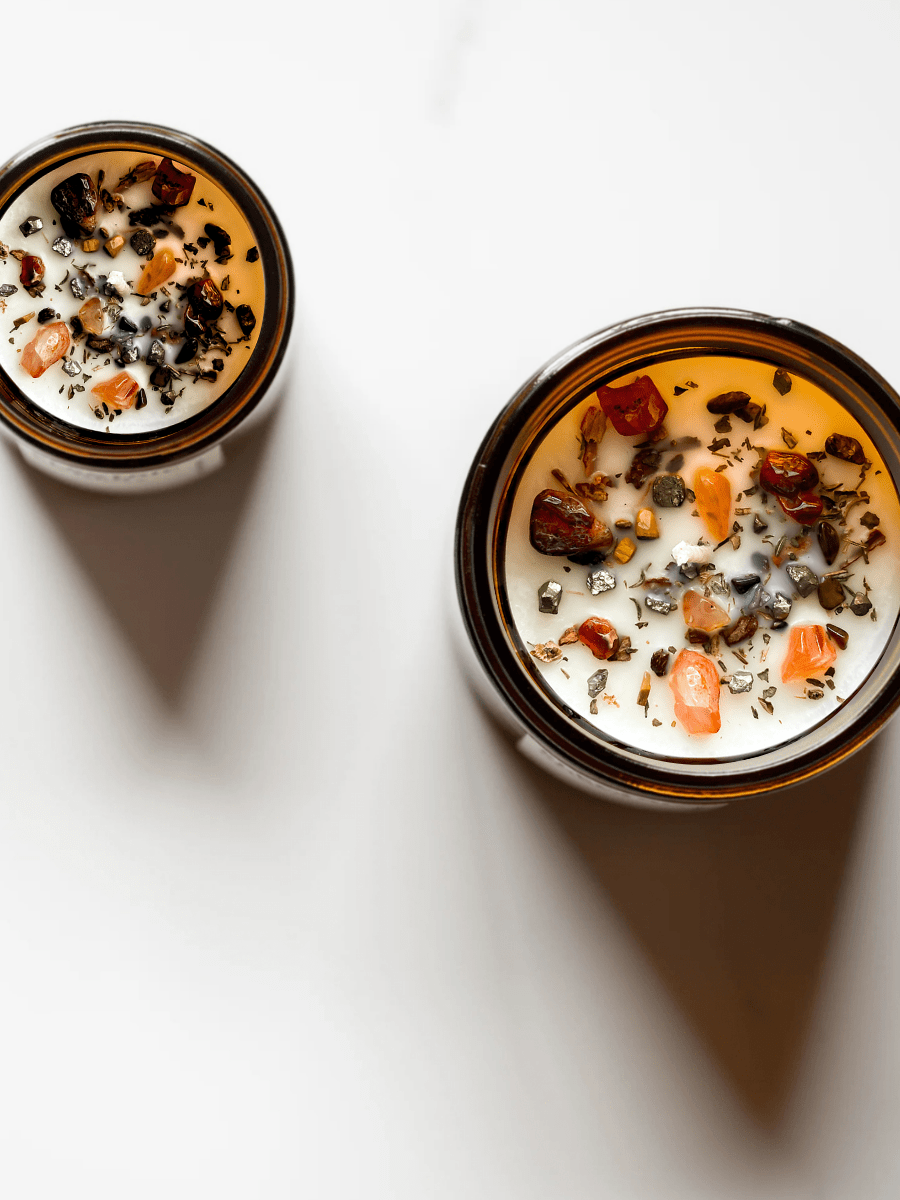 Top view of I. The Magician ritual candle with carnelian, tiger's eye, pyrite, and botanicals.