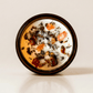I. The Magician ritual candle with carnelian, pyrite, tiger's eye, and botanical details viewed from above.