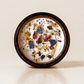 II. The High Priestess ritual candle with lapis lazuli, tiger's eye, quartz, and botanical details viewed from above.