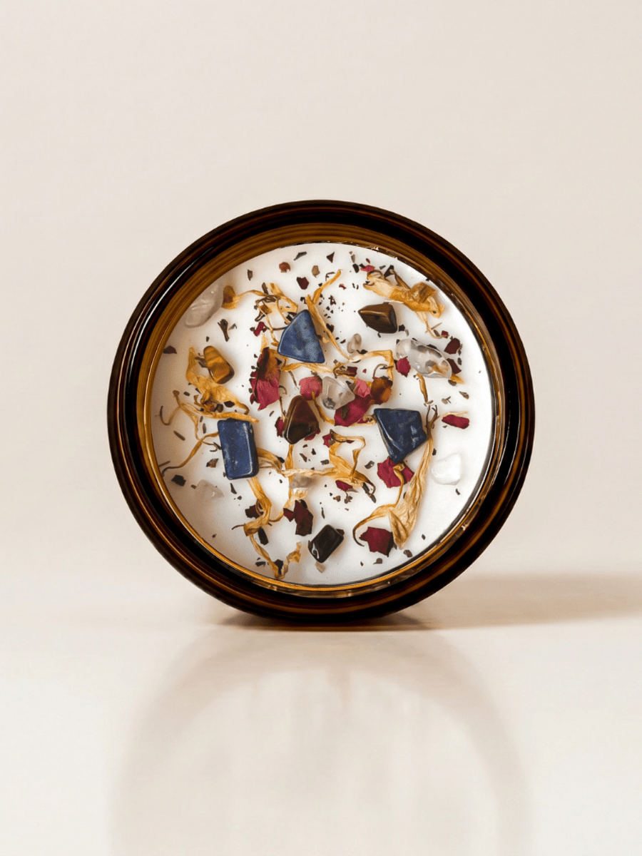 II. The High Priestess ritual candle with lapis lazuli, tiger's eye, quartz, and botanical details viewed from above.