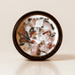 III. The Empress ritual candle with rose quartz, moonstone, unakite, and botanical details viewed from above.
