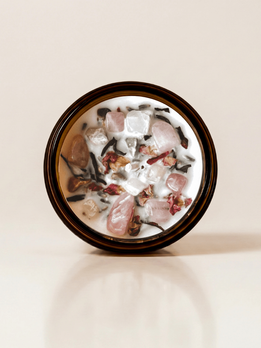 III. The Empress ritual candle with rose quartz, moonstone, unakite, and botanical details viewed from above.