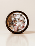 III. The Empress ritual candle with rose quartz, moonstone, unakite, and botanical details viewed from above.