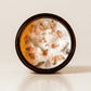 Lotus ritual candle with rose quartz, quartz, and botanical details viewed from above.