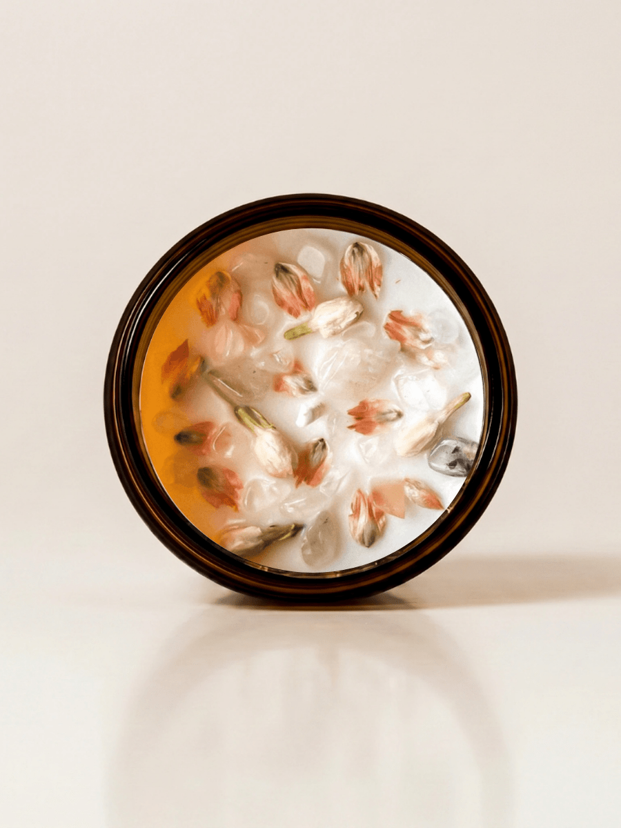 Lotus ritual candle with rose quartz, quartz, and botanical details viewed from above.