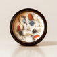 Meditate ritual candle with carnelian, lapis lazuli, amethyst, and botanical details viewed from above.