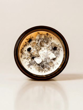 Morning Affirmations in Hazelnut ritual candle with smoky quartz, moonstone, super seven, tiger's eye, and botanical details viewed from above.