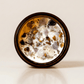 Morning Affirmations ritual candle with tiger's eye, super seven, smoky quartz, and botanical details viewed from above.