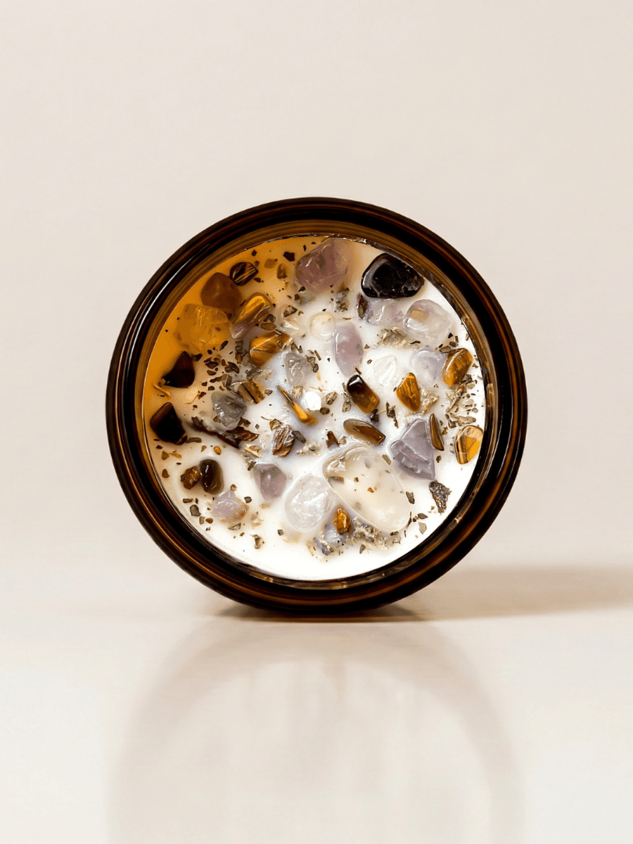 Morning Affirmations ritual candle with tiger's eye, super seven, smoky quartz, and botanical details viewed from above.