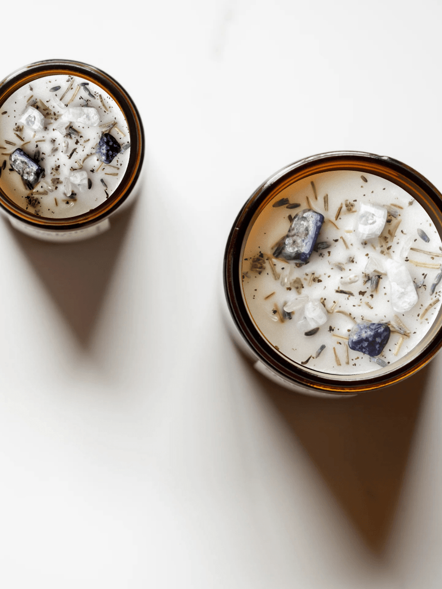 Top view of New Moon ritual candles with lapis lazuli, moonstone, quartz, and botanicals.