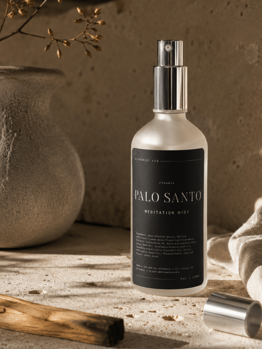 Palo Santo Meditation Mist by Alchemist + Co beside Palo Santo wood in warm sunlight.