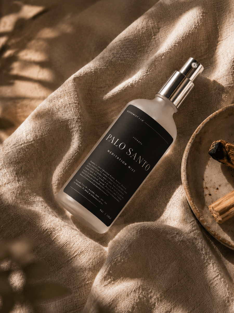Palo Santo Meditation Mist resting on linen beside Palo Santo sticks and ceramic dish.